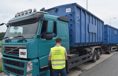 Inspektor Wojewódzkiego Inspektoratu Ochrony Środowiska w Warszawie kontroluje samochód ciężarowy.